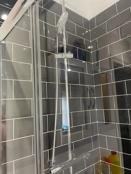 Glass shower enclosure showing the shower head and chrome fittings
