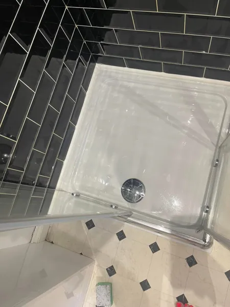 White shower tray and glass enclosure viewed from above