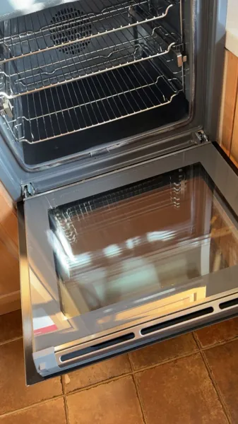 Open oven showing the interior racks and glass oven door